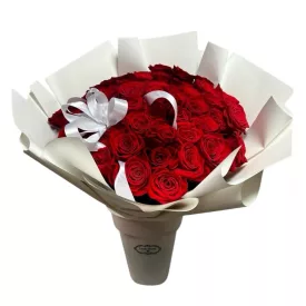   50 szálas vörös rózsa csokor fehér díszpapírban szalaggal, vázában
